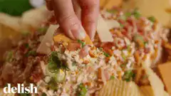 Hand dipping chip into loaded dip
