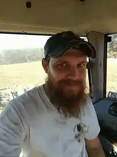 Bearded man winking in tractor