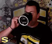Man drinks from mug and laughs