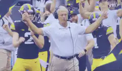 Jim Harbaugh celebrating with Michigan players