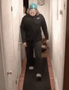 Man in blue hat trips and falls in hallway