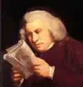 Man reading paper then looking up confused