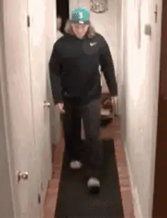 person flips over couch in hallway