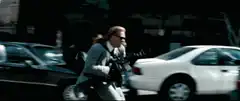 Man shooting gun behind car