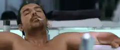 shirtless man smoking in bathtub