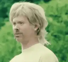 David Spade talking in a green tinted scene