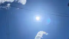 sun and power lines in blue sky