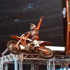 Motocross rider celebrating mid-air