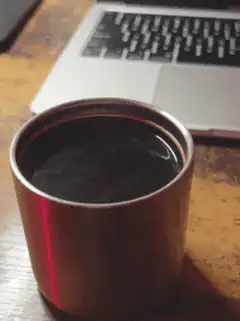 coffee cup next to laptop