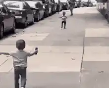 Toddler runs to hug another child on sidewalk