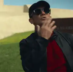 Man in sunglasses blows a kiss and points