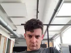 Man with curly hair looking at camera