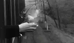 Hand holding paper out of moving train window