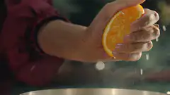 Hand squeezing orange juice