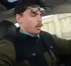 Man in car with sunglasses on head