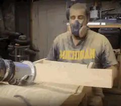 Man covered in sawdust sneezes
