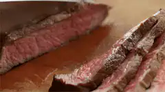 Slicing a juicy medium-rare steak