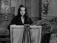 Woman painting in front of a tiki statue