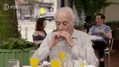 Old man sips juice with straw