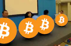 Bitcoin logos rolling across a meeting room