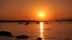 Sunset over water with boat