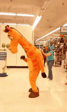 Giraffe mascot dancing in store