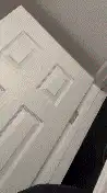 Man peeks out from behind door