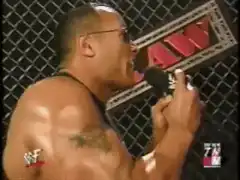 The Rock speaks in the ring and fans hold signs
