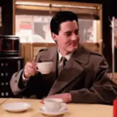 Kyle MacLachlan sipping coffee smugly