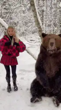 Girl and bear in snowy forest