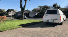 White Cadillac hearse pulls into driveway