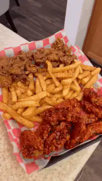 Fried chicken and crinkle-cut fries on checkered paper