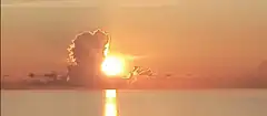 Sunset over water with cloud silhouette