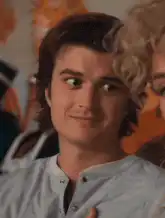 Joe Keery smirking and looking around