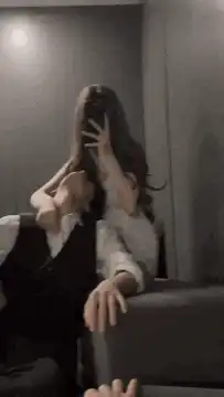 woman taking mirror selfie with man