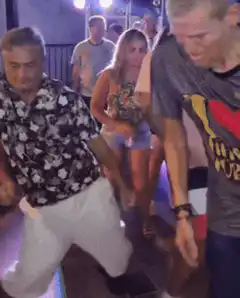 Man in floral shirt dancing at a club