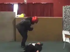 Man in red helmet lifts table over friend