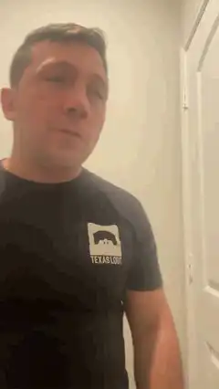 Man in Texas Loot shirt looking around