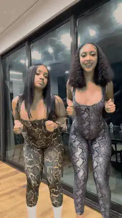 Two women dancing in snake print bodysuits