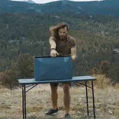 Man opens large box in mountains