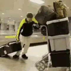 man struggling with luggage cart