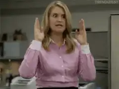 A woman in a pink shirt raises her hands in frustration