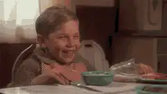 Young boy laughing at dinner