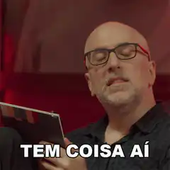 Bald man with glasses says tem coisa aí