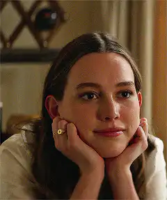 woman resting chin on hands smiling