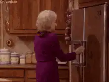 Woman opens fridge door