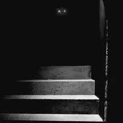 Glowing eyes on dark stairs