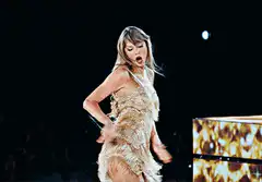 Taylor Swift dancing in gold dress