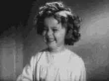 Shirley Temple laughing and covering her mouth