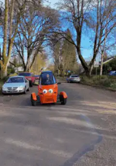 Orange three-wheeled car with googly eyes